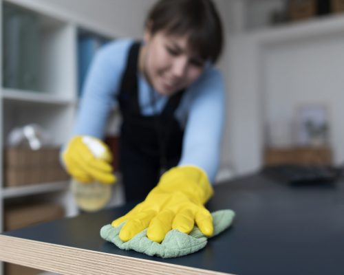 Mujer limpiando mesa de trabajo