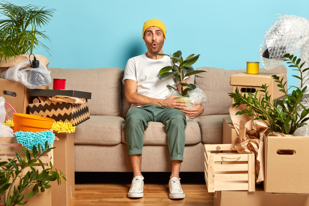Hombre sentado en mueble con planta en la mano